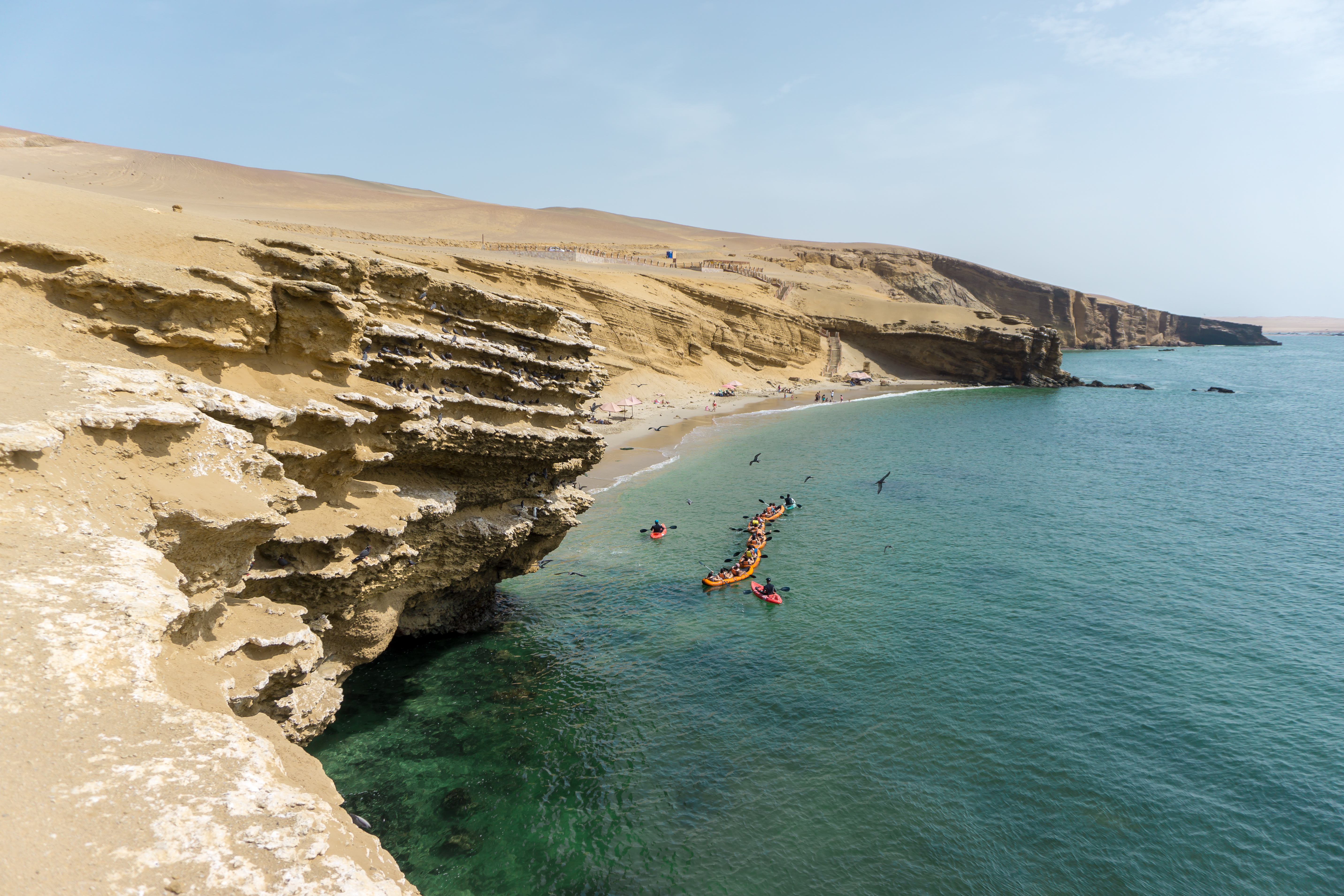 Peru Beautiful Beach In Paracas National Parc, Peru. Kayak Navigating The Turquoise Crystal Clear Water.